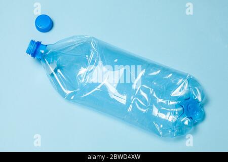 Crumpled plastic bottles on a blue background. Plastic trash. Stock Photo