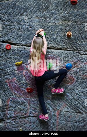 Girl having fun during rock climbing training on boulder wall Stock Photo