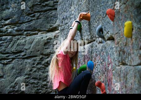 Girl having fun during rock climbing training on boulder wall Stock Photo