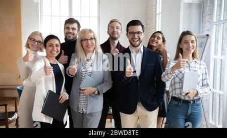 Excited group of diverse businesspeople showing thumbs up gesture. Stock Photo