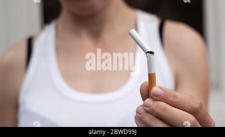 girl holds a broken cigarette in her hand close-up. stop smoking, health concept, bad habit. Stock Photo
