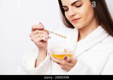 Young woman uses liquid wax to remove hair Stock Photo
