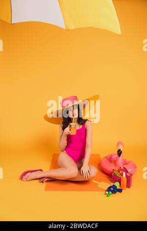 Portrait of girl wearing bikini top leaning against tree