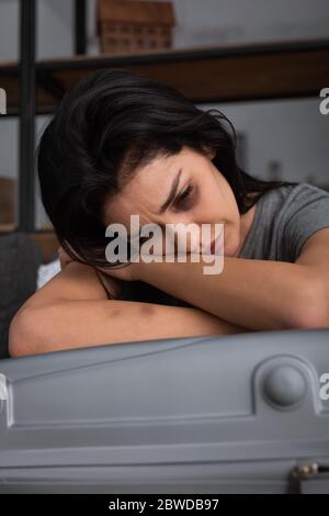 depressed woman with bruise on face crying near suitcase, domestic violence concept Stock Photo