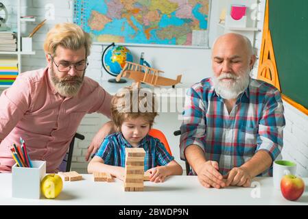 Happiness family life style concept. Parenting childhood values weekend. Male multi generation portrait. Grangfather, Father and son playing jenga Stock Photo