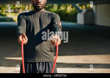 Cropped image of serious sportsman offering his skipping rope after her finished training Stock Photo
