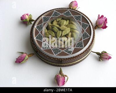 Mashhad, IRAN, 01 03 2020: Beautiful handcraft box with cardamom pods  with flower decoration on white background. Aromatic spice. Stock Photo
