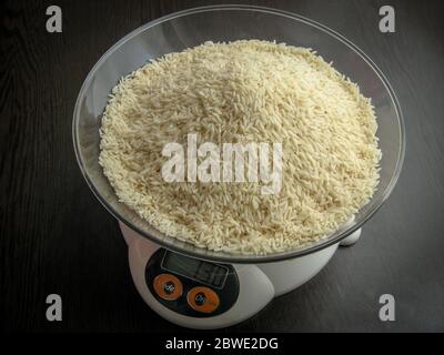 White rice on a digital scale. Raw uncooked hashemi local rice Stock Photo