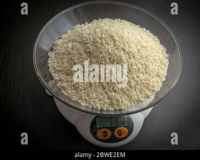 White rice on a digital scale. Raw uncooked hashemi local rice Stock Photo