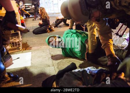 Beijing, USA. 30th May, 2020. Riot police officers arrest a small group of protestors at a memorial to George Floyd in Minneapolis, the United States, on May 30, 2020. Minnesota Governor Tim Walz on Saturday activated 'full mobilization' of the Minnesota National Guard after four straight nights of violent protests in the midwest state's biggest city Minneapolis over the death of George Floyd, an unarmed black man, in police custody. Credit: Angus Alexander/Xinhua/Alamy Live News Stock Photo