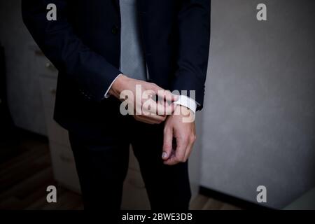 man puts on suit in the room Stock Photo
