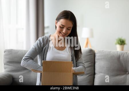 Satisfied woman unpacking box smiling enjoy fast delivery service Stock Photo