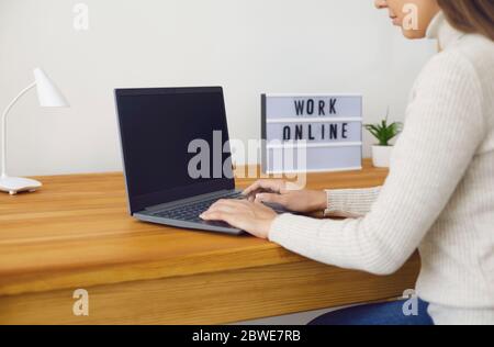 Female freelancer using laptop working online in modern workspace. Stock Photo