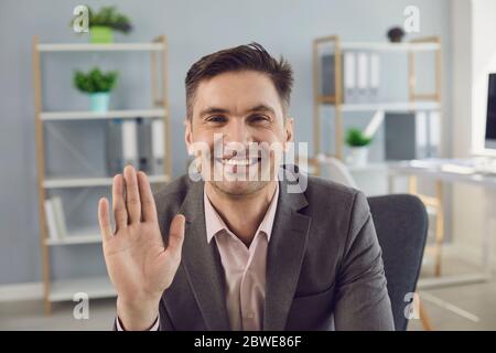 Mature businessman comminucating online looking at camera from home office. Entrepreneur conducting corporate video chat conference through webcam Stock Photo