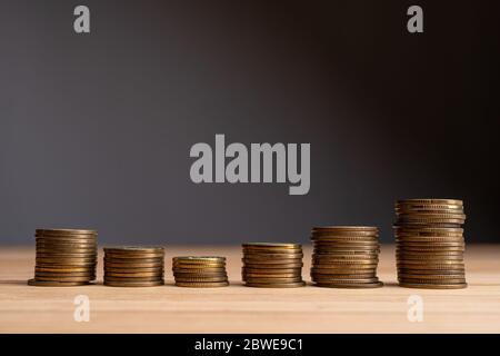 Stacks of coins on a natural wood background. Finance market growth abstract concept. Copy space at the top. Stock Photo