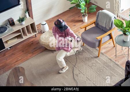 Teenager girl wear vr headset play virtual reality game at home, top view. Stock Photo