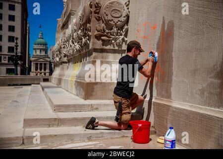 Christopher Saxon, an Afghanistan veteran suffering from PTSD, tries to clean graffiti off the war memorial after the riots in response to the killing of George Floyd and Sean Reed in Indianapolis.Saxon said he served with Golf Company, 1st Platoon, of the 2nd Battalion, 5th Marines, in Afghanistan during 2012, and is 100-percent disabled for PTSD. Saxon said he got anxiety just going to the memorial but said, 'I fought for people's rights, and freedom of speech. Saxon called the police who killed George Lloyd, 'garbage people,' but said not all police are bad. He said he felt the graffiti on Stock Photo