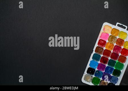 Used palette of watercolor paints. Materials for creativity. Top view with copy space, flat lay. Stock Photo