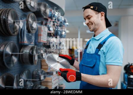 Male worker choosing disc for saw in tool store Stock Photo
