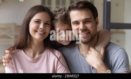 Portrait of young family with small son hugging Stock Photo