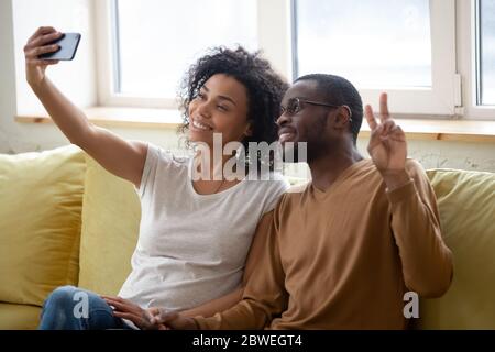 African couple in love using smartphone taking selfie photo Stock Photo