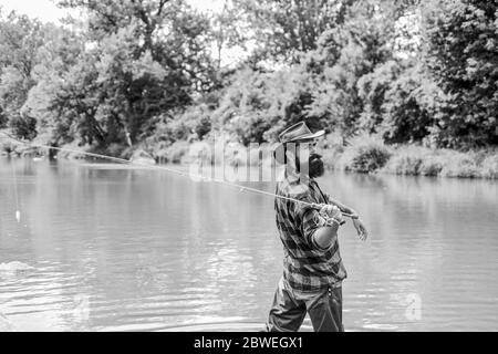 Born to Fish. hobby and sport activity. pothunter. bearded fisher in water. mature man fly fishing. man catching fish. summer weekend. Big game fishing. fisherman with fishing rod. Stock Photo