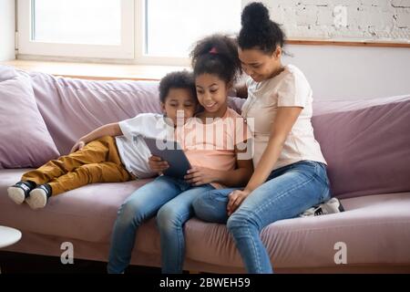 African mother spend free time with kids using tablet gadget Stock Photo