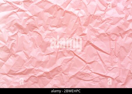 Crumpled paper texture. Pastel pink trendy abstract background. Stock Photo
