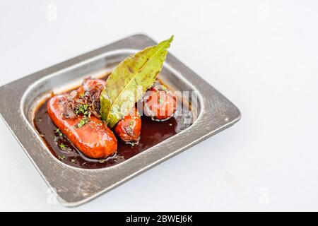 Frying pan with delicious grilled sausages on table. Gastronomy culinary appetizer wurst prepared in metal pan Stock Photo