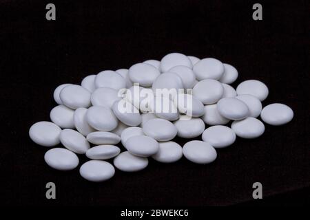 White pills on a dark background. Subject macro photography. Stock Photo