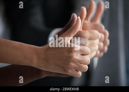 Close up diverse team showing thumbs up, like gesture Stock Photo