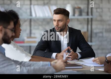 Confident businessman team leader speaking, leading corporate meeting Stock Photo