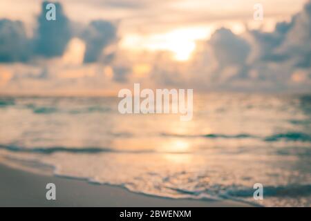 Blur sunset beach with bokeh sun light wave abstract background. Beautiful sea bokeh wave and the light of the sun. Stock Photo