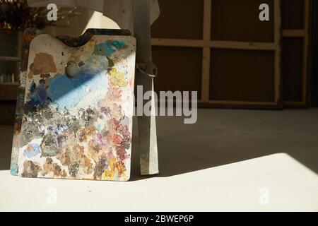 Background image of colorful artists palette lit by sunlight in empty art studio interior, copy space Stock Photo