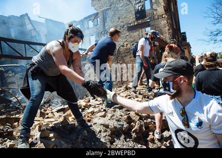 Beijing, USA. 30th May, 2020. Community members clean up debris after a protest over the death of George Floyd in Minneapolis, the United States, on May 30, 2020. TO GO WITH XINHUA HEADLINES OF JUNE 1, 2020 Credit: Angus Alexander/Xinhua/Alamy Live News Stock Photo