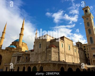 Church of Saint George Maronite and Mohammad Al-Amin Mosque coexist side by side in Downtown Beirut Stock Photo