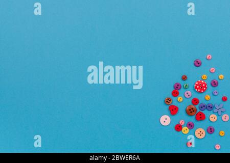 Multicolored buttons are scattered on the table. Top view with copy space, flat lay. Stock Photo