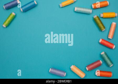 Multicolored cotton threads, spools, handmade sewing. Top view with copyspace, flat lay. Stock Photo