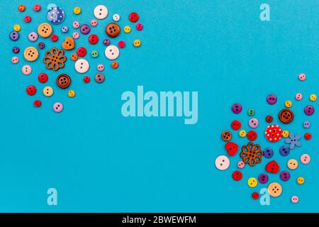 Multicolored buttons are scattered on the table. Top view with copy space, flat lay. Stock Photo