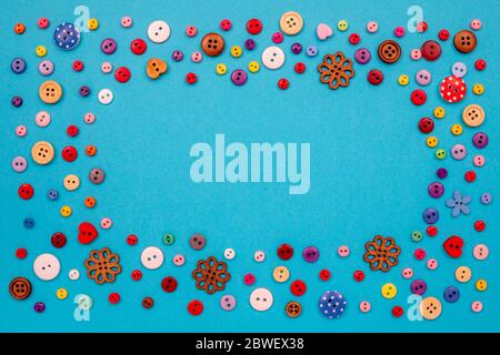 Multicolored buttons are scattered on the table. Top view with copy space, flat lay. Stock Photo