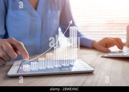 Business success and profit displayed by 3d growing bar chart, successful businesswoman working in bright office with computer and digital tablet, man Stock Photo