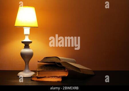 Elegance white desk lamp with yellow lampshade near open book Stock Photo