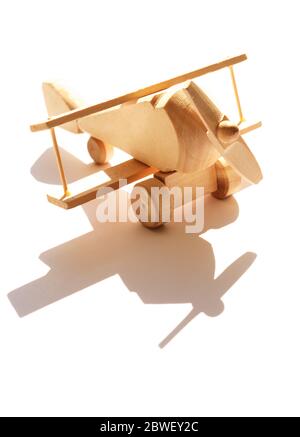 Travel concept. Small wooden airplane against sunlight with shadow Stock Photo