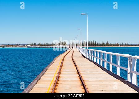 Busselton, Nov 2019: Train tracks on Busselton Jetty, Western Australia. Seaside landscape with Indian Ocean waters Stock Photo
