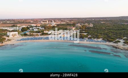 Aerial bird's eye view of Landa beach, Ayia Napa, Famagusta, Cyprus. The landmark tourist attraction golden sand bay at sunrise with sunbeds, sea rest Stock Photo