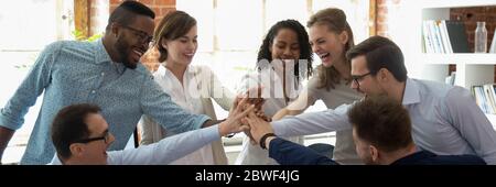 Happy multi ethnic colleagues celebrating success giving high five Stock Photo