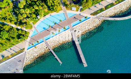 Aerial view of Molos Promenade park on the coast of Limassol city centre in Cyprus. Bird's eye view of the jetties, beachfront walk path, palm trees, Stock Photo