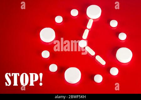 Clock made of white tablets with inscription STOP on red background, top view. 2019 Novel Coronavirus 2019-nCoV concept Stock Photo
