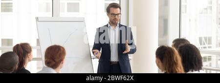 Trainer makes presentation during seminar using flipchart horizontal photo Stock Photo