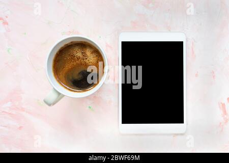 Cup of black coffee and tablet on pink background Stock Photo